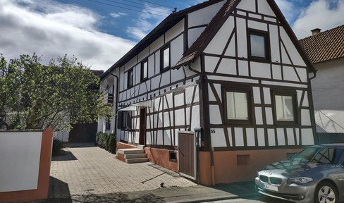 From private owner with expansion potential: half-timbered house with extension, barn, PV system and garden